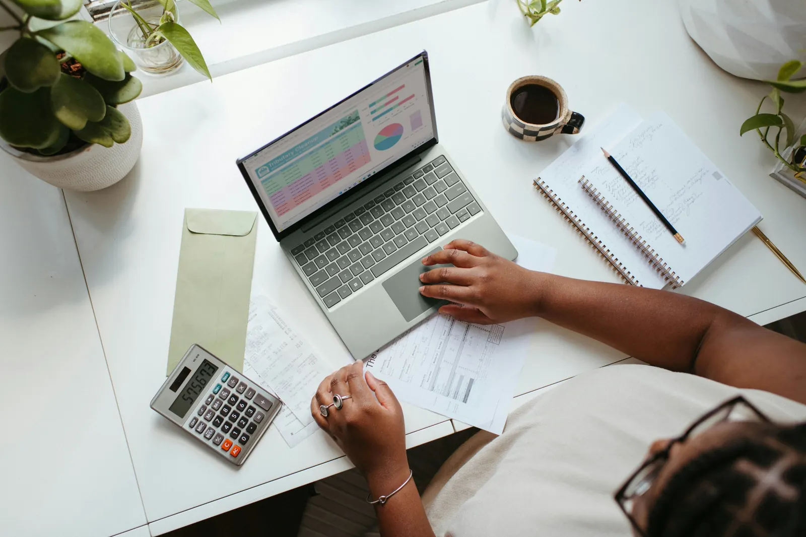 Desk with laptop, calculator and notebook for reviewing a quote