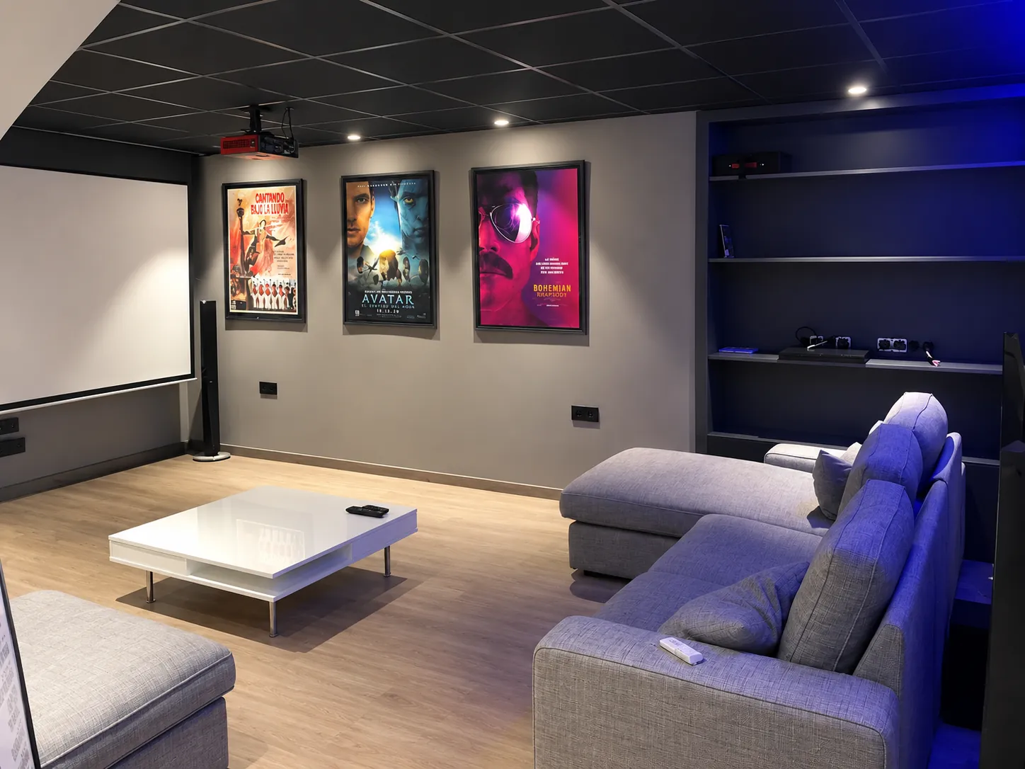 Home cinema with projector, screen, corner sofa and built-in shelving