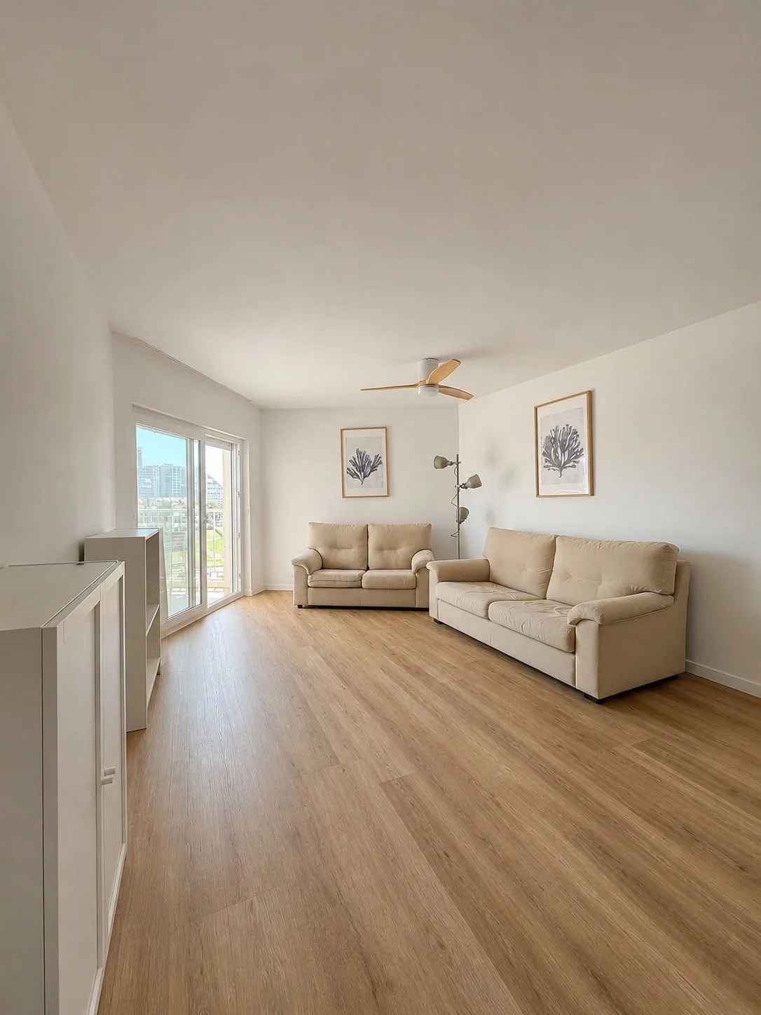 Bright living room with laminate flooring, two sofas and access to the terrace